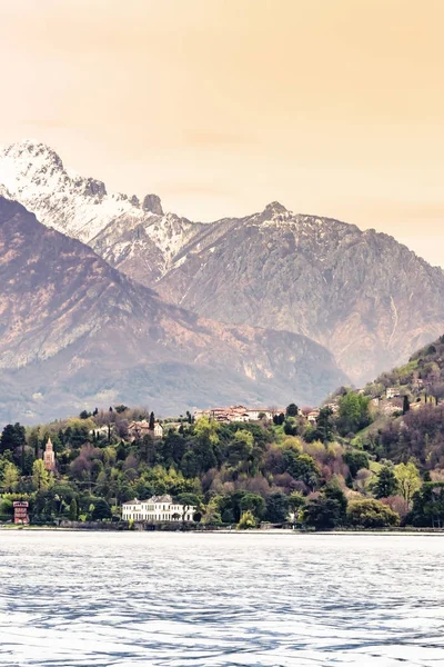 Villa in Como lake Italy with snow and mountain looking from boat in Lenno side