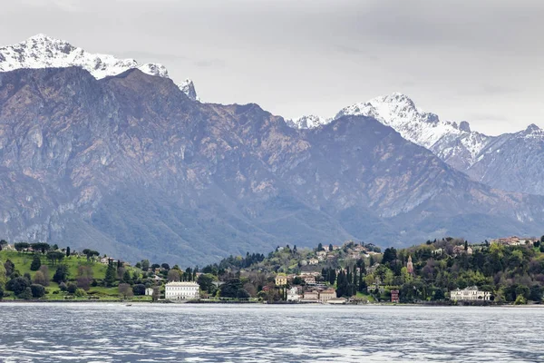 Villa in Como lake Italy with snow and mountain looking from boat in Lenno side