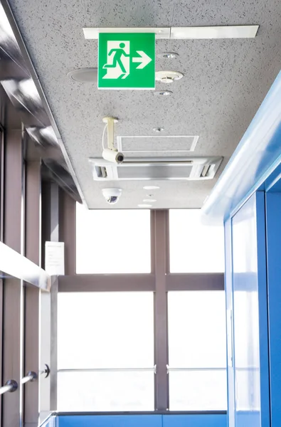 Exit Sign lignt met CCTV en camera onder plafond voor veiligheid — Stockfoto