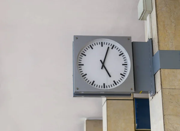 Черно-белые часы с металлической рамой на стене — стоковое фото