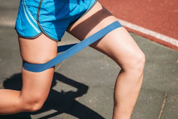 Close Uma Faixa Elástica Fitness Nas Pernas Uma Jovem Mulher — Fotografia de Stock