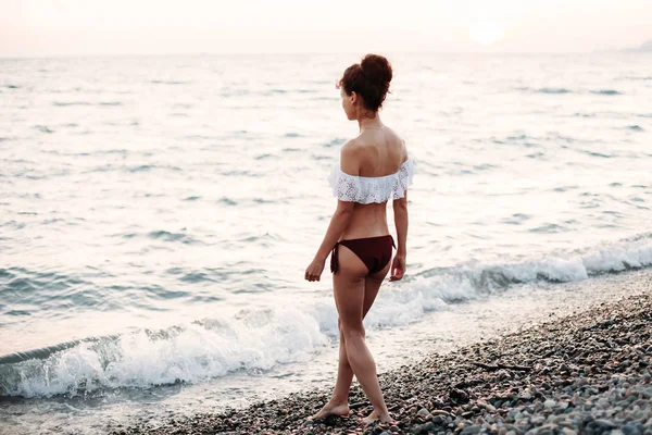 美しい若い女性は 海のビーチで水に歩く — ストック写真