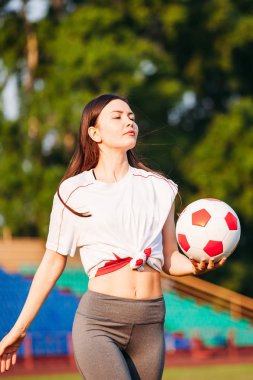 Futbol topu futbol sahasında b ellerinde olan kadın