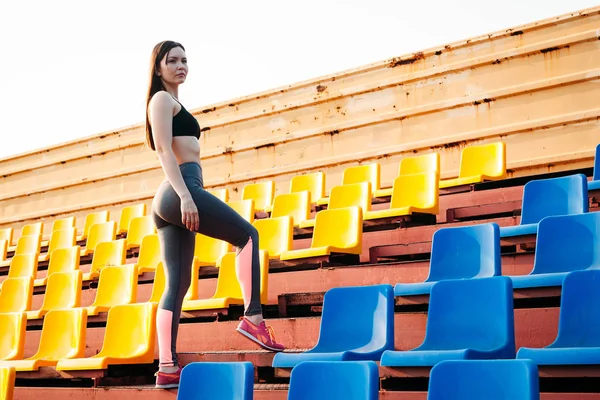 Sexy ragazza sportiva in posa allo stadio. Fitness ragazza con uno sport fi — Foto Stock