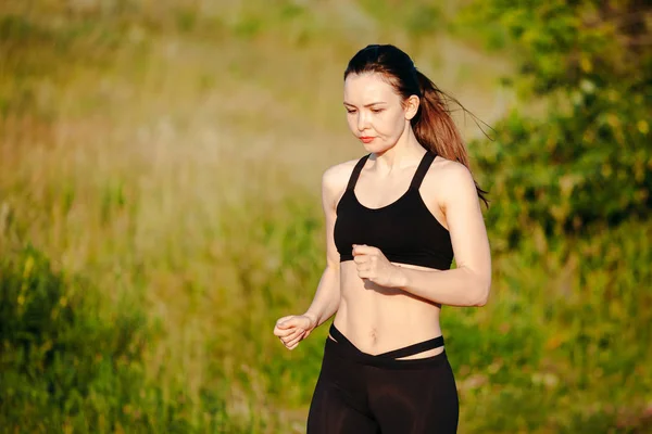 Jeune femme sportive engagée dans la course du matin d'été dans le parc. dans — Photo