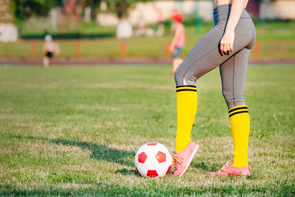 Ung kvinna fotbollsspelare med boll på fältet — Stockfoto