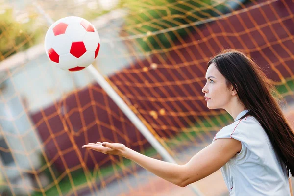 Donna portiere lancia palla in piedi a porta di calcio — Foto Stock