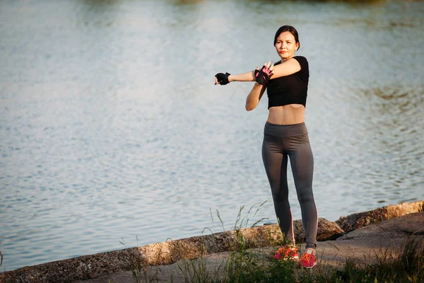 Ragazza palestra vicino al lago in città Parco. Fitness in natura. Buongiorno e — Foto Stock