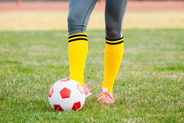 Jovem jogador de futebol chuta bola no campo de futebol — Fotografia de Stock