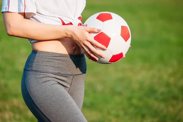 Close-up atlético jovem sexy menina no campo de futebol com bola em — Fotografia de Stock