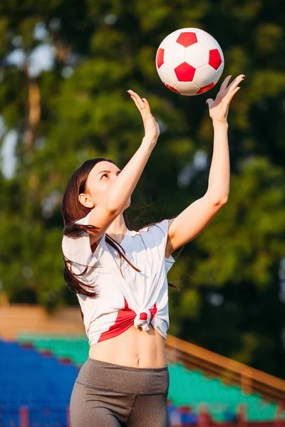 Genç sportif kadın futbol topu atar. — Stok fotoğraf
