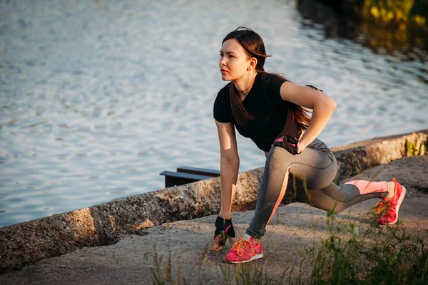 La salle de gym fille près du lac dans le parc de la ville. Fitness dans la nature. Morni. — Photo