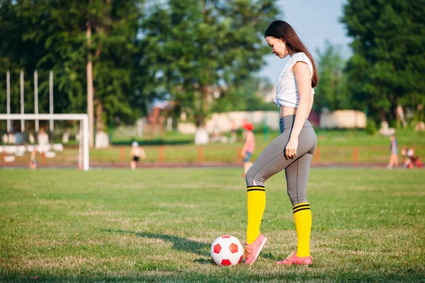 Mulher chutando bola de futebol — Fotografia de Stock