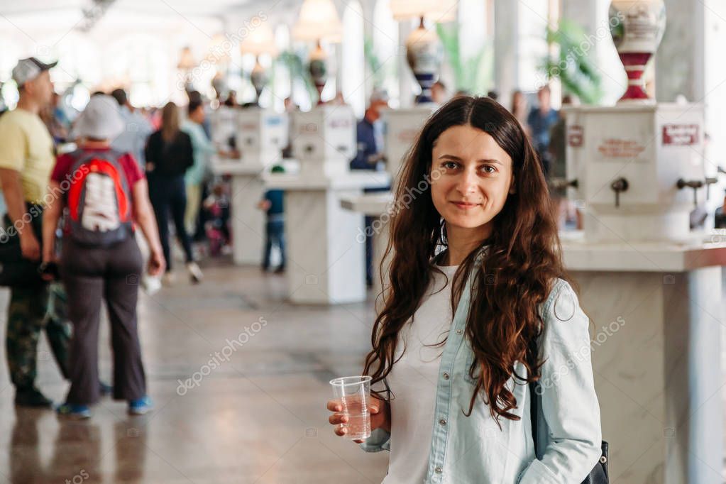 young woman with glass mineral water Narzan gallery in Kislovods