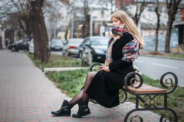 在城市中的长椅上坐着的女人 — 图库照片