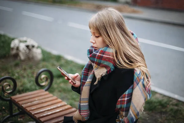 Портрет красивая молодая женщина на скамейке на городском фоне взгляд — стоковое фото