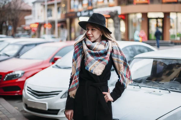 Young woman in black coat, hat and scarf. girl walking around ci — Stock Photo, Image