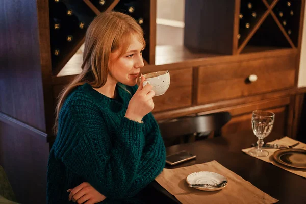 Junge Frau im Café trinkt Tasse Kaffee — Stockfoto