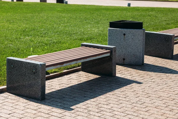 Banco del parque de madera y piedra y un cubo de basura para los residuos —  Fotos de Stock