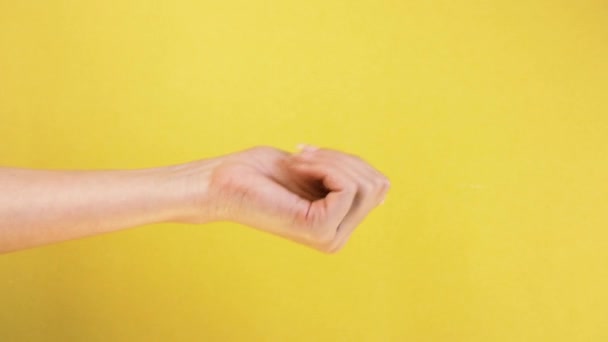 Come here or come on gesture. female hand on yellow background, beckoning and inviting gesture isolated — Stock Video