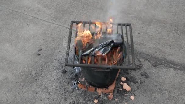 Geschmolzener heißer Teer in einem Eimer auf den Ziegeln. Dachreparatur. Feuer aus Eimer. Gitter auf Eimer — Stockvideo