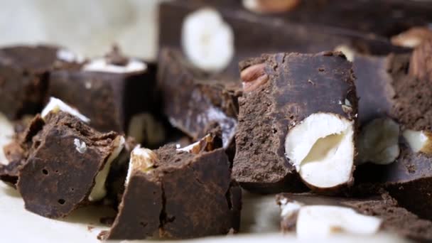 Mano femenina toma rebanada de chocolate negro orgánico con avellanas. concepto de uso del cacao — Vídeo de stock