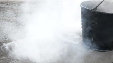 Katranla çatı onarımı. Çatıdaki çatlakları ve eklemleri dolduran erimiş katranla çalışmak