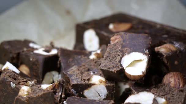 Primer plano de dedos femeninos tomar un pedazo de chocolate negro con nueces. el concepto de daño dulce — Vídeos de Stock