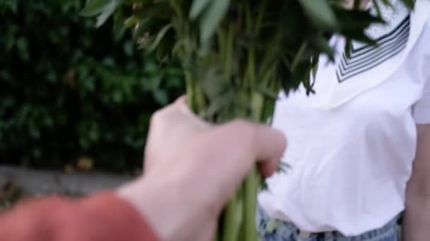 Чоловік дарує молодій жінці букет квітів. 4-кілометровий — стокове відео