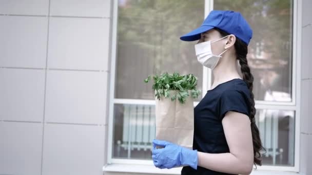 Kurir, leverans man i skyddsmask och medicinska handskar levererar hämtmat. Leveransservice under karantän, sjukdomsutbrott, coronavirus covid-19 pandemiska förhållanden. Stanna hemma — Stockvideo