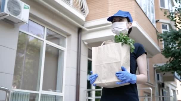 Corriere, fattorino in maschera protettiva e guanti medici consegna cibo da asporto. Servizio di consegna in quarantena, epidemia di malattia, coronavirus covid-19 pandemia. Resta a casa. — Video Stock