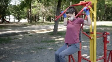 Koruyucu maskeli ve eldivenli genç bir kadın spor için Park 'a gidiyor. Sosyal uzaklık kavramı