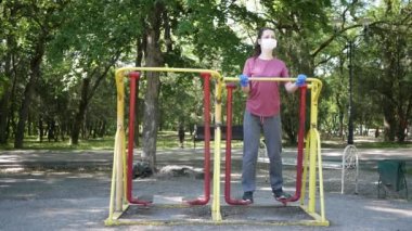 Koruyucu maskeli ve eldivenli genç bir kadın spor için Park 'a gidiyor. Sosyal uzaklık kavramı