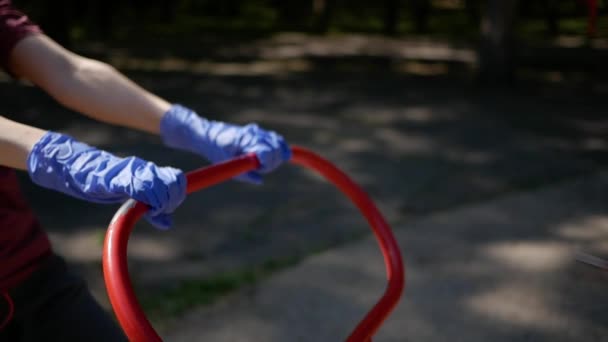 Jovem mulher em máscara protetora e luvas, vai para esportes em equipamentos de exercício ao ar livre no Parque. O conceito de distanciamento social — Vídeo de Stock