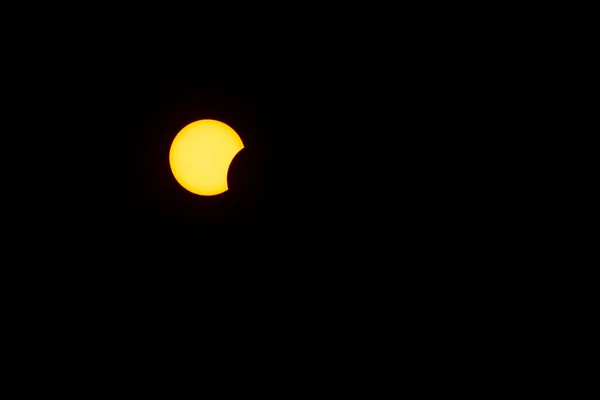 Księżyc pokrywa słońce częściowym zaćmieniem słońca na ciemnym niebie. — Zdjęcie stockowe