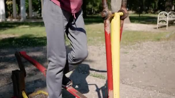 Concetto di distanza sociale. Giovane donna entra per lo sport in simulatore nel parco sulla maschera protettiva e guanti. Vista telecamera dal basso verso l'alto — Video Stock