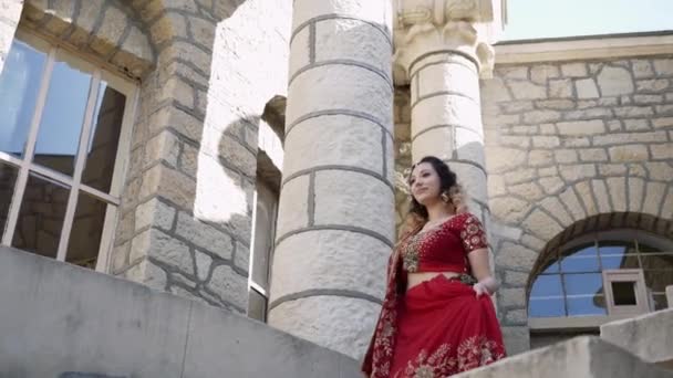 Прекрасний індійський сарі. Молода жінка в червоному, барвистому, чуттєвому, весільному і дуже жіночому вбранні - індійський сарі ходить старими вулицями Індії. Традиційний національний одяг індійських жінок — стокове відео