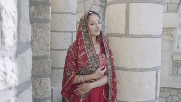 Bella Saree indiana etnica. Giovane donna in abito rosso, colorato, sensuale, da sposa e molto femminile - il sari indiano passeggia per le vecchie strade dell'India. Abbigliamento nazionale tradizionale delle donne indiane — Video Stock