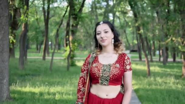 Retrato de uma jovem mulher em saree indiano andando no parque — Vídeo de Stock