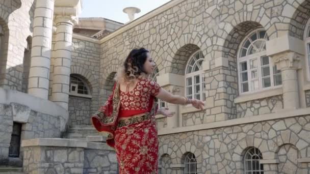 인도의 고대 건축 도시 인도의 거리에서 전통적 인 장식물 로장 식되어 있는 붉은 사리 옷을 입고 춤을 추는 인도 여성들과 메헬렌 디의 손에 새겨진 그림 — 비디오