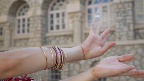 Mani in primo piano donna indiana danza sulle strade dell'antica città di architettura dell'India vestita in rosso Sari, decorata con ornamenti tradizionali e disegni di hennè Mehendi su mani — Video Stock