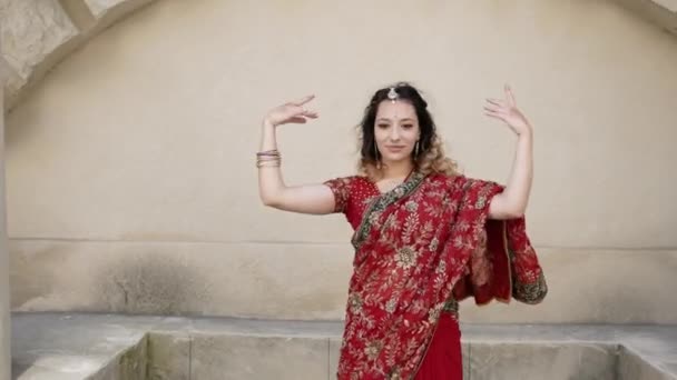 Mujer india danza en las calles de la antigua arquitectura de la ciudad de la India vestida de rojo Sari, decorado con adornos tradicionales y patrones Mehendi dibujos de henna en las manos — Vídeos de Stock