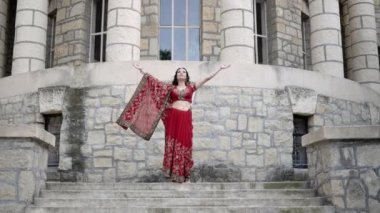 Renkli Hint sarisi giymiş genç bir kadın geleneksel Hindu selamı olan Namaste 'de el ele tutuşuyor. Çekici kadın gülümsüyor, saygı ve konukseverliğini ifade ediyor.