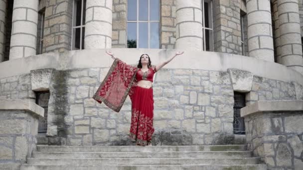 Young woman in colorful ethnic Indian sari joins hands in Namaste, traditional Hindu greeting. Attractive woman smiling, expresses its respect and hospitality — Stock Video