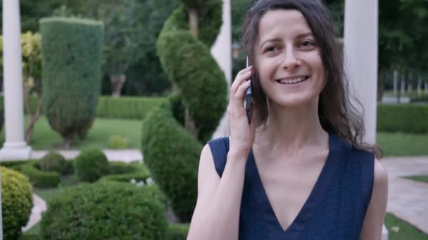 Retrato jovem, ela marca telefone, chamando alguém, falando e sorrindo verão ao ar livre — Vídeo de Stock