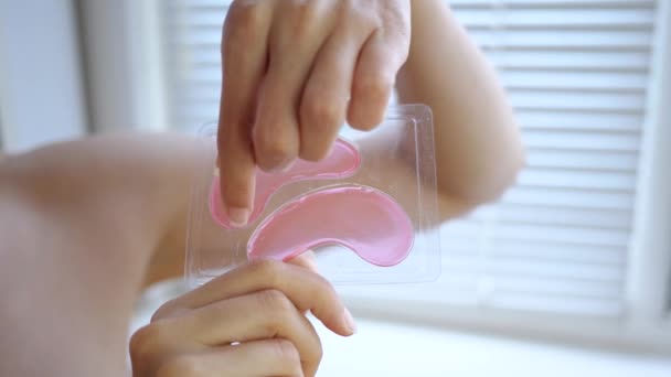 Closeup of a female hand takes the patches from the package — Stock Video