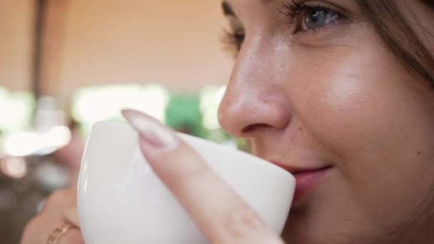 Junge Frau in Restaurant trinkt Kaffee aus nächster Nähe — Stockvideo