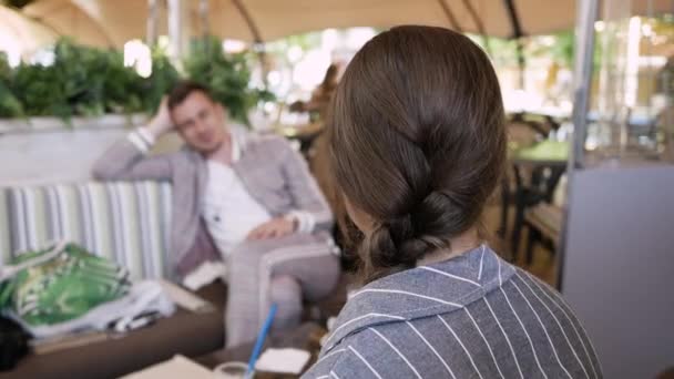 Conversación de negocios. mujer joven hablando con el hombre en la cafetería y los gestos — Vídeo de stock