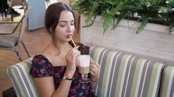 Mujer en la cafetería al aire libre bebiendo café a través de paja, riendo, tonteando — Vídeo de stock