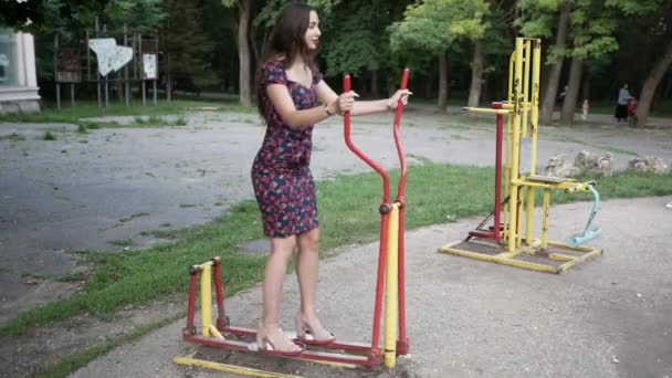 Business woman in shoes and dress is working out on outdoor exercise μηχανές — Αρχείο Βίντεο